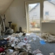 Foto eines verwahrlosten und vollgemüllten Zimmers - Martina Wagner Immobilien