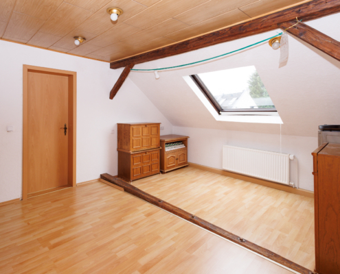 großer Wohnflur im OG der Betreiberwohnung mit dekorativem Holzbalkon, Dachfenster und Zugang zum Schlafzimmer